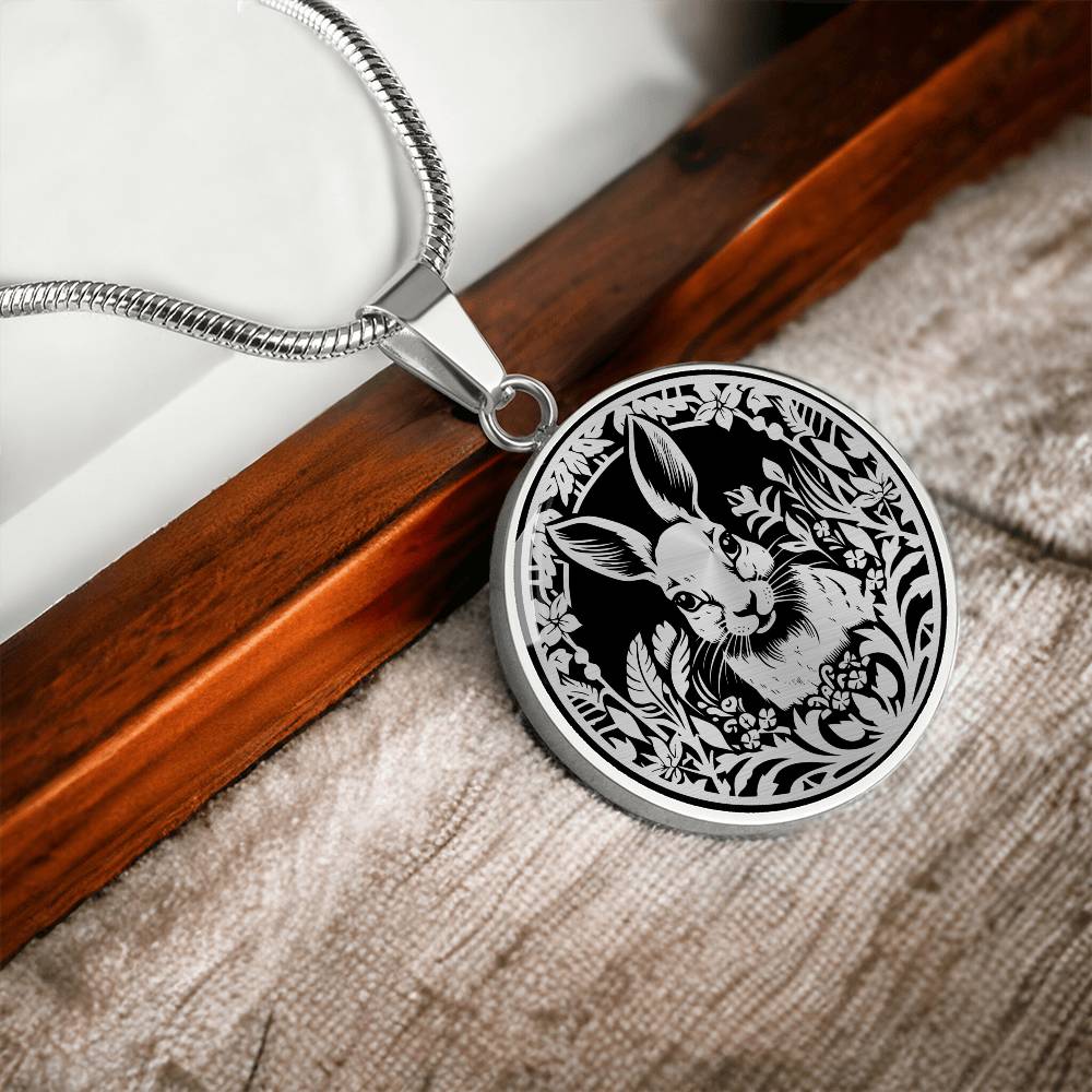 Elegant silver pendant featuring a Rabbit silhouette, The rabbit is hiding in the grass, set against a black backdrop. This necklace offers personalization with an engraving option for a name.