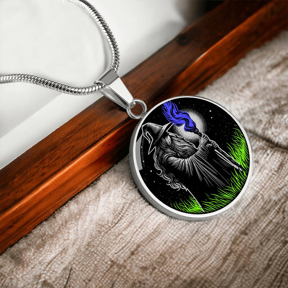 An Elegant silver pendant featuring a Fantasy Wizard Necklace, with green grass, blue fire with a silver and black background. This jewelry offers personalization with an engraving option for a name.