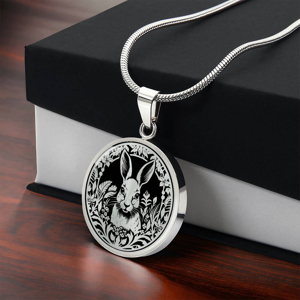 Gift box with an Elegant silver pendant featuring a Rabbit silhouette, The rabbit is hiding in the grass, set against a black backdrop. This necklace offers personalization with an engraving option for a name.