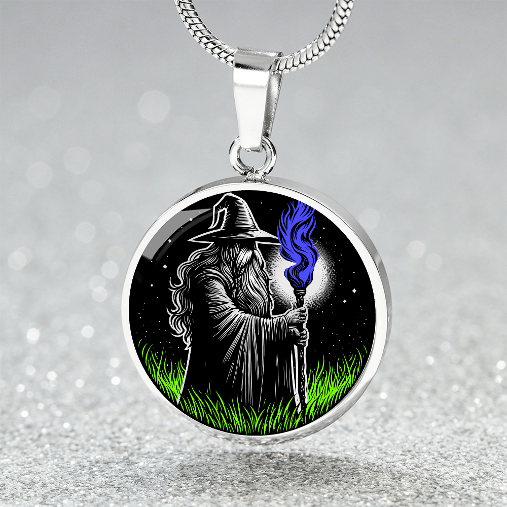 An Elegant silver pendant featuring a Fantasy Wizard Necklace, with green grass, blue fire with a silver and black background. This jewelry offers personalization with an engraving option for a name.