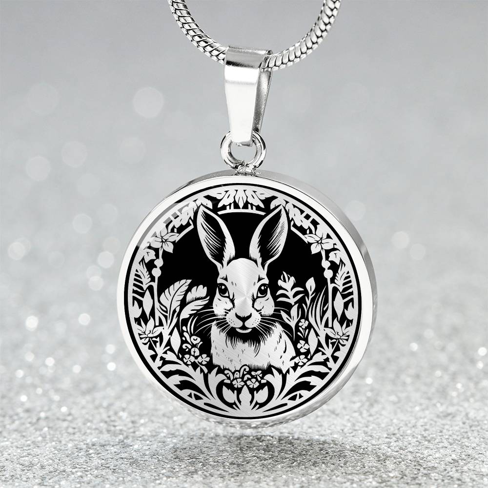 Elegant silver pendant featuring a Rabbit silhouette, The rabbit is hiding in the grass, set against a black backdrop. This necklace offers personalization with an engraving option for a name.