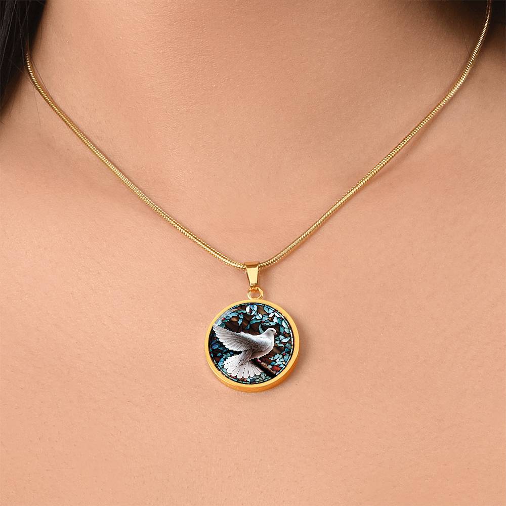 Woman wearing an Elegant gold pendant Dove Bird Necklace. featuring a white dove, green, blue, red colored border, leaves, berries with a brown background. This jewelry offers personalization with an engraving option for a name.