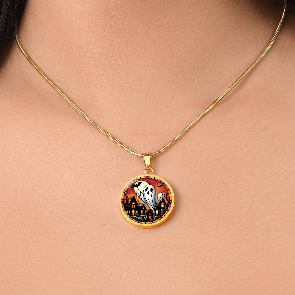 Woman wearing an elegant gold pendant Halloween Ghost Necklace. The colors are white, black, yellow, orange and green. This jewelry offers personalization with an engraving option for a name.
