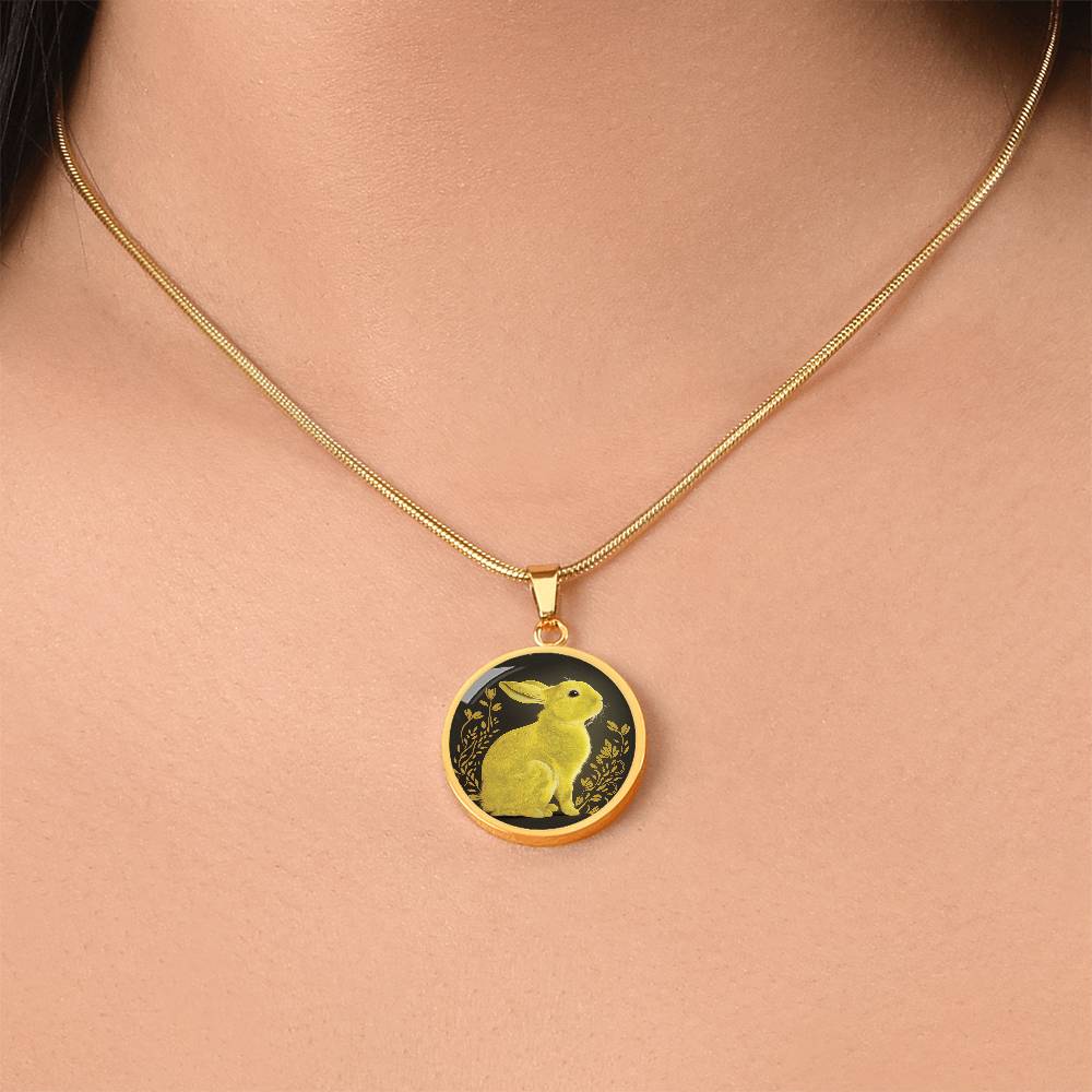 Woman wearing an Elegant gold pendant Rabbit Necklace. Yellow Rabbit and Flowers with a black and brown backdrop. This jewelry offers personalization with an engraving option for a name.