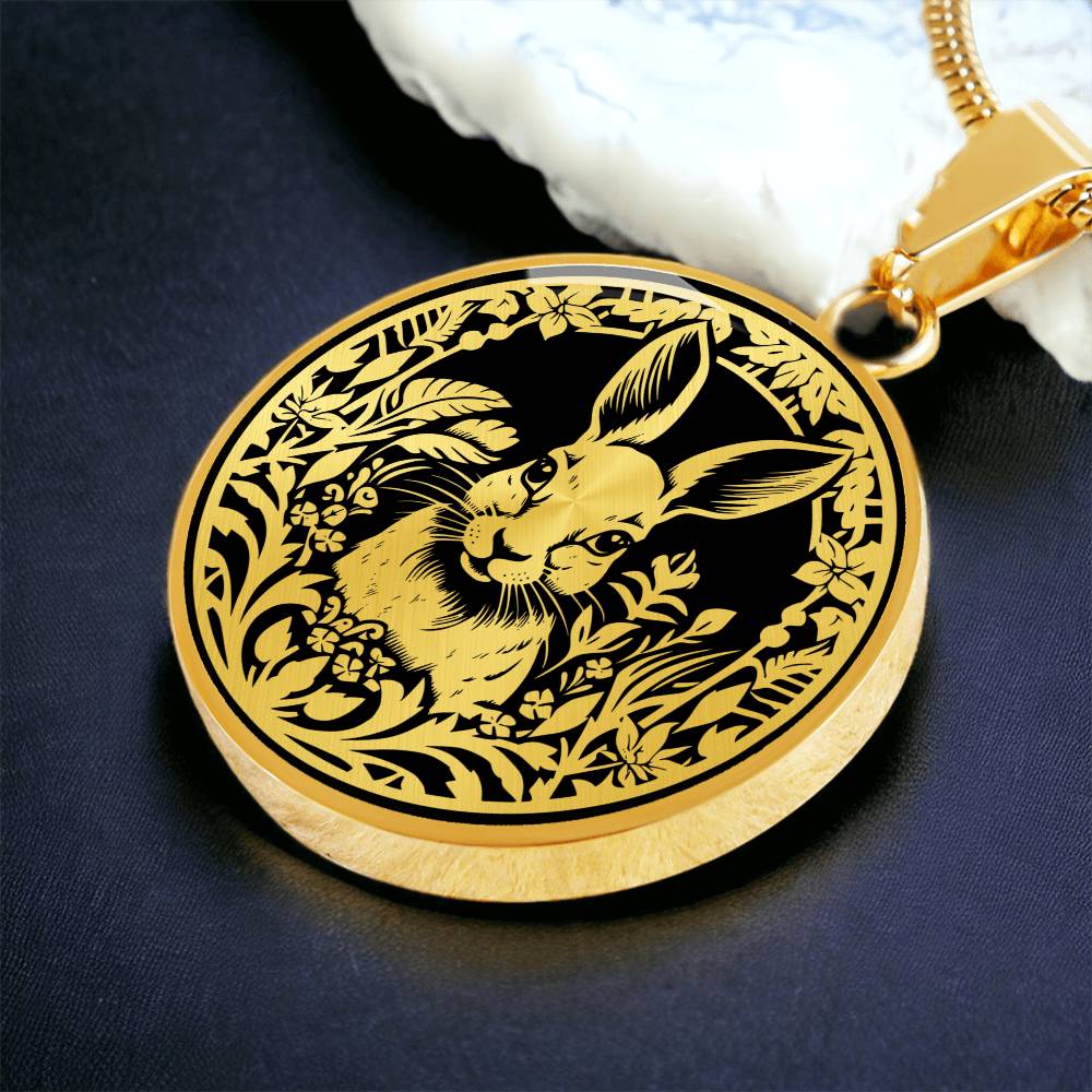 Elegant gold pendant featuring a Rabbit silhouette, The rabbit is hiding in the grass, set against a black backdrop. This necklace offers personalization with an engraving option for a name.