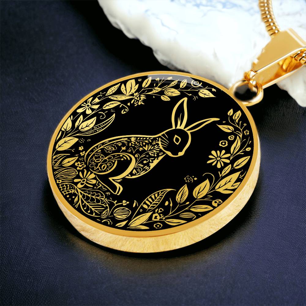 an Elegant gold pendant Easter Bunny necklace featuring Silver bunny with leaves and flowers all in gold with a black background. This jewelry offers personalization with an engraving option for a name.