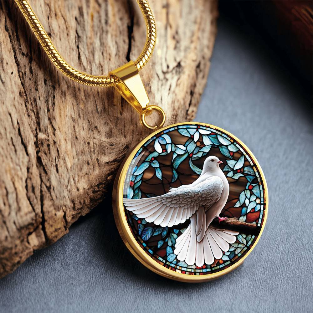 an Elegant gold pendant Dove Bird Necklace. featuring a white dove, green, blue, red colored border, leaves, berries with a brown background. This jewelry offers personalization with an engraving option for a name.