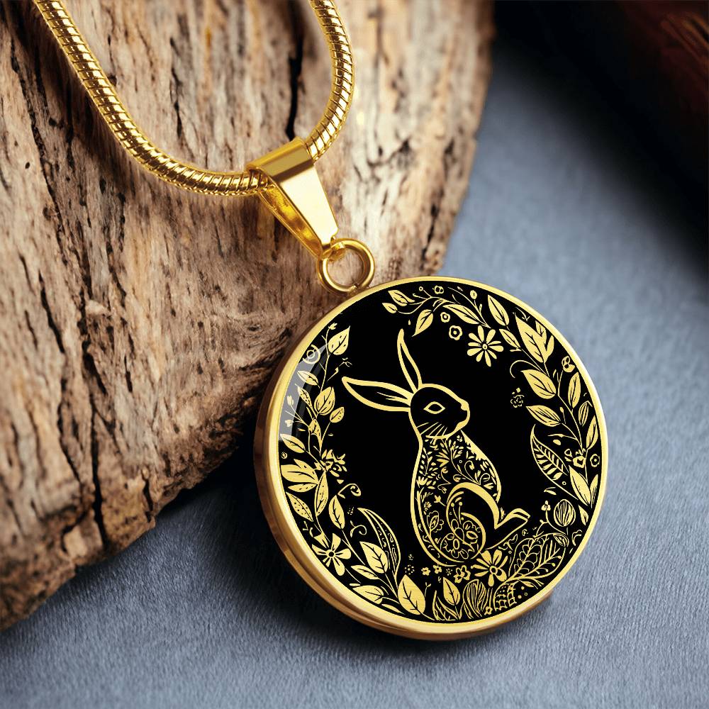 an Elegant gold pendant Easter Bunny necklace featuring Silver bunny with leaves and flowers all in gold with a black background. This jewelry offers personalization with an engraving option for a name.