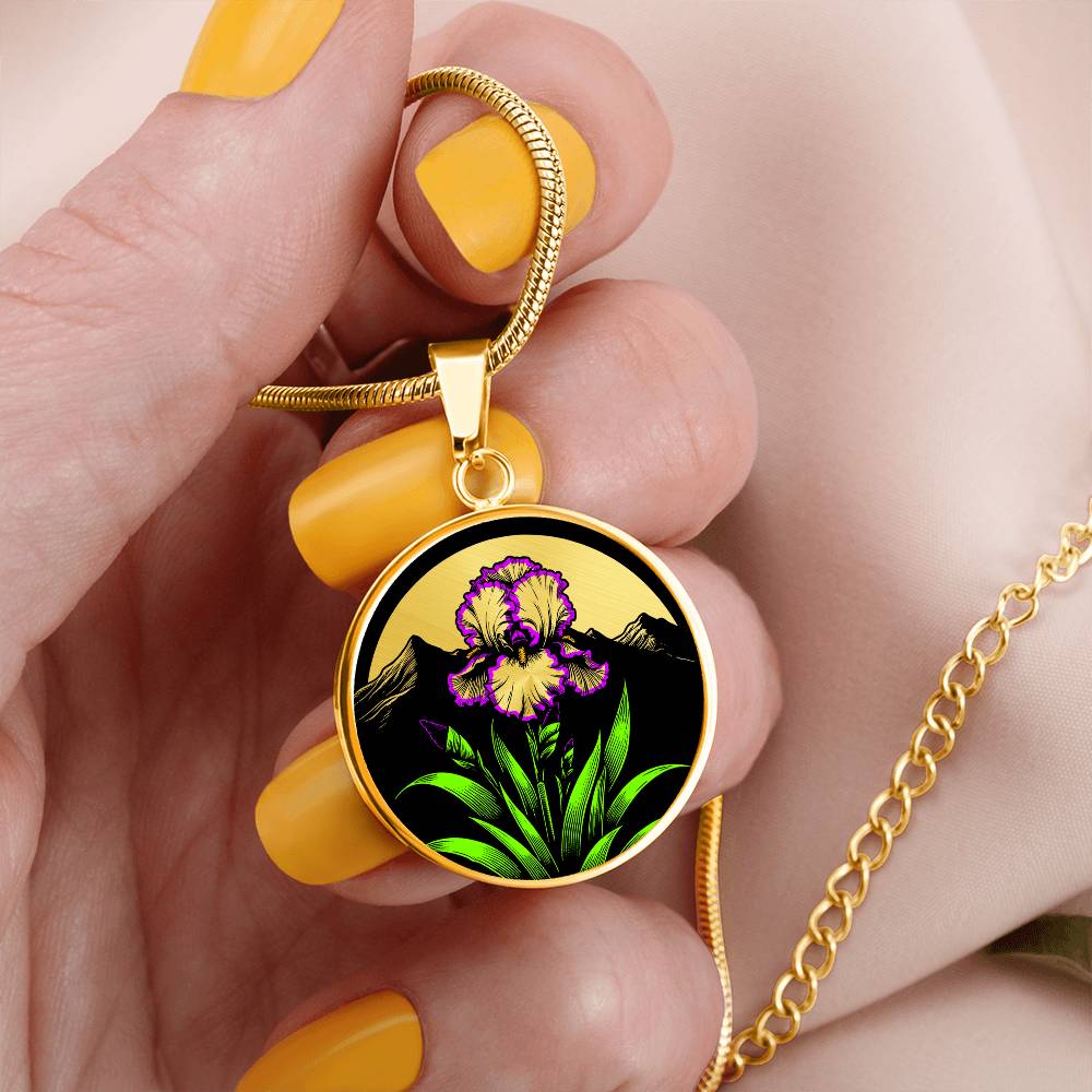 Woman holding a Februarys birth month flower Elegant gold pendant featuring a vivid Purple Iris Necklace set against a Green Grass, Gold sun and mountains background. This necklace offers personalization option for a name.