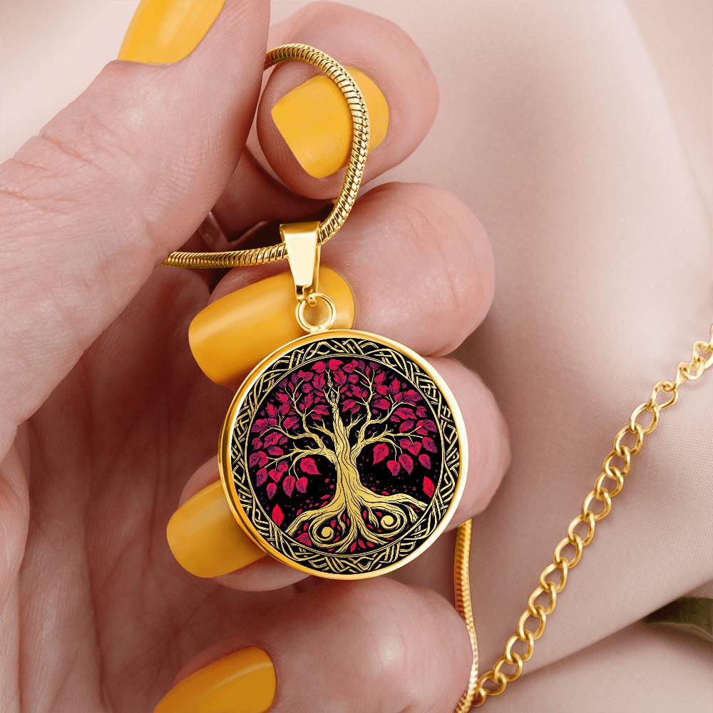 Woman holding an Elegant gold pendant Tree of Life necklace featuring a vivid Celtic red and gold tree, set against a black backdrop. This jewelry offers personalization with an engraving option for a name.