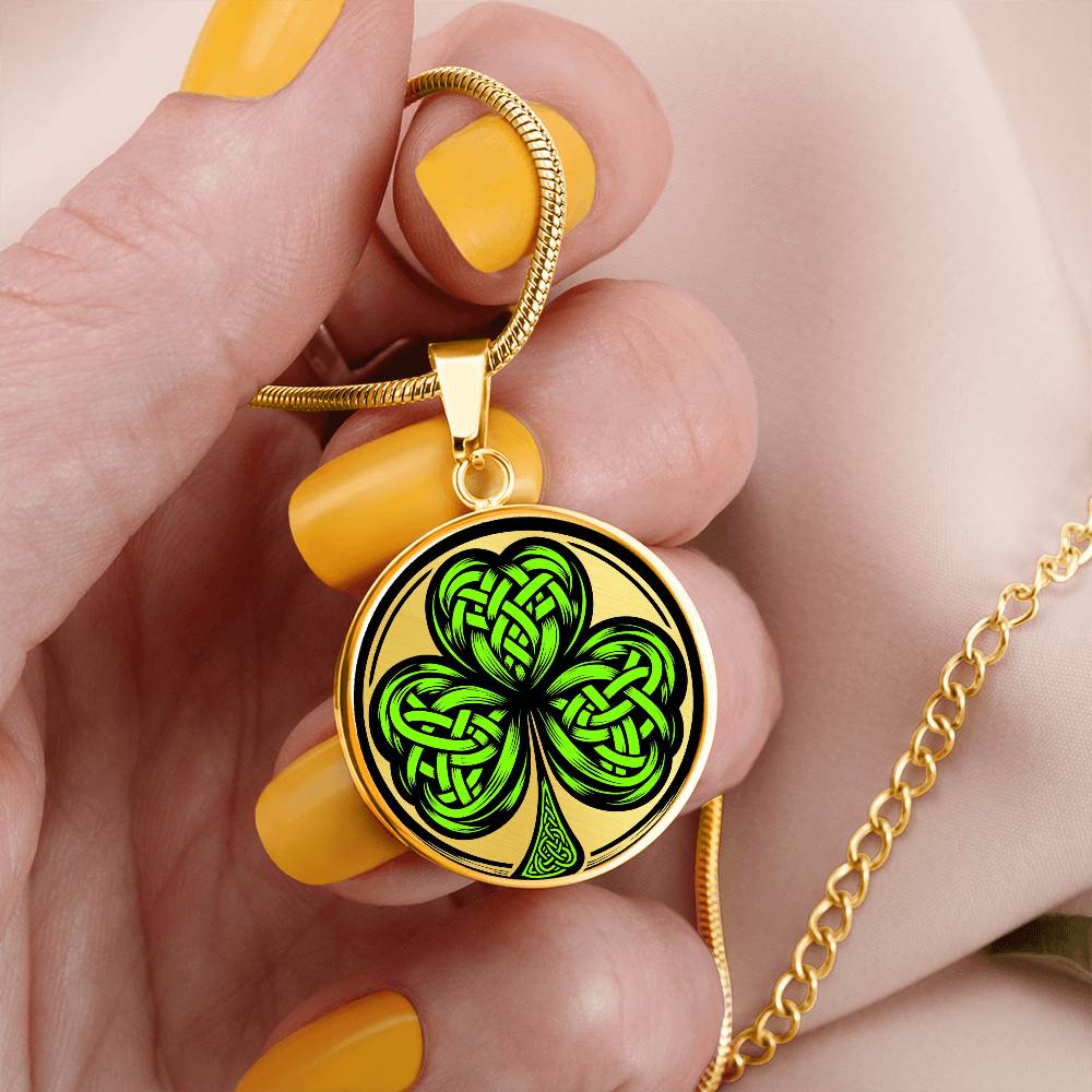 Woman holding an Elegant gold pendant necklace featuring a vivid Green Celtic Clover set against a Gold & black backdrop. This necklace offers personalization with an engraving option for a name.