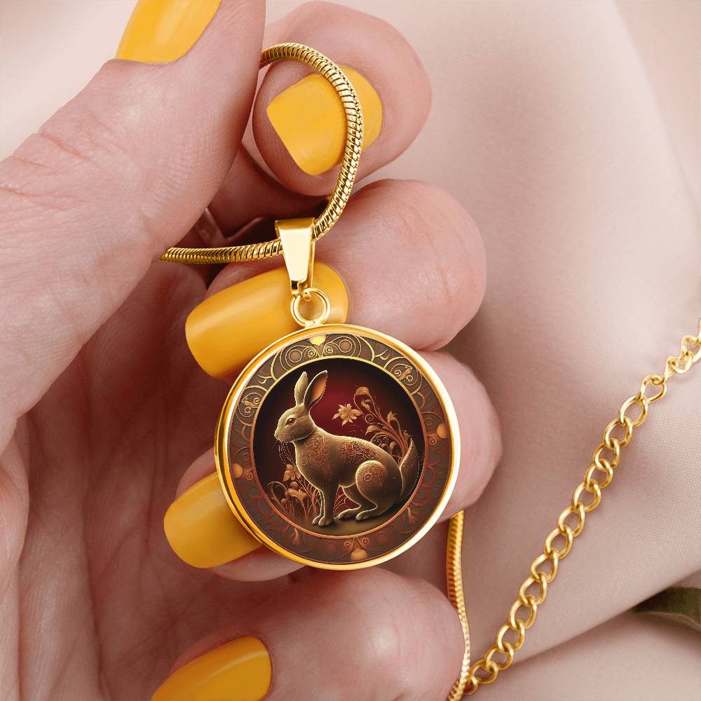 Woman holding an elegant gold pendant Bunny Rabbit Necklace. The Colors are Red, Yellow and Black. This jewelry offers personalization with an engraving option for a name.