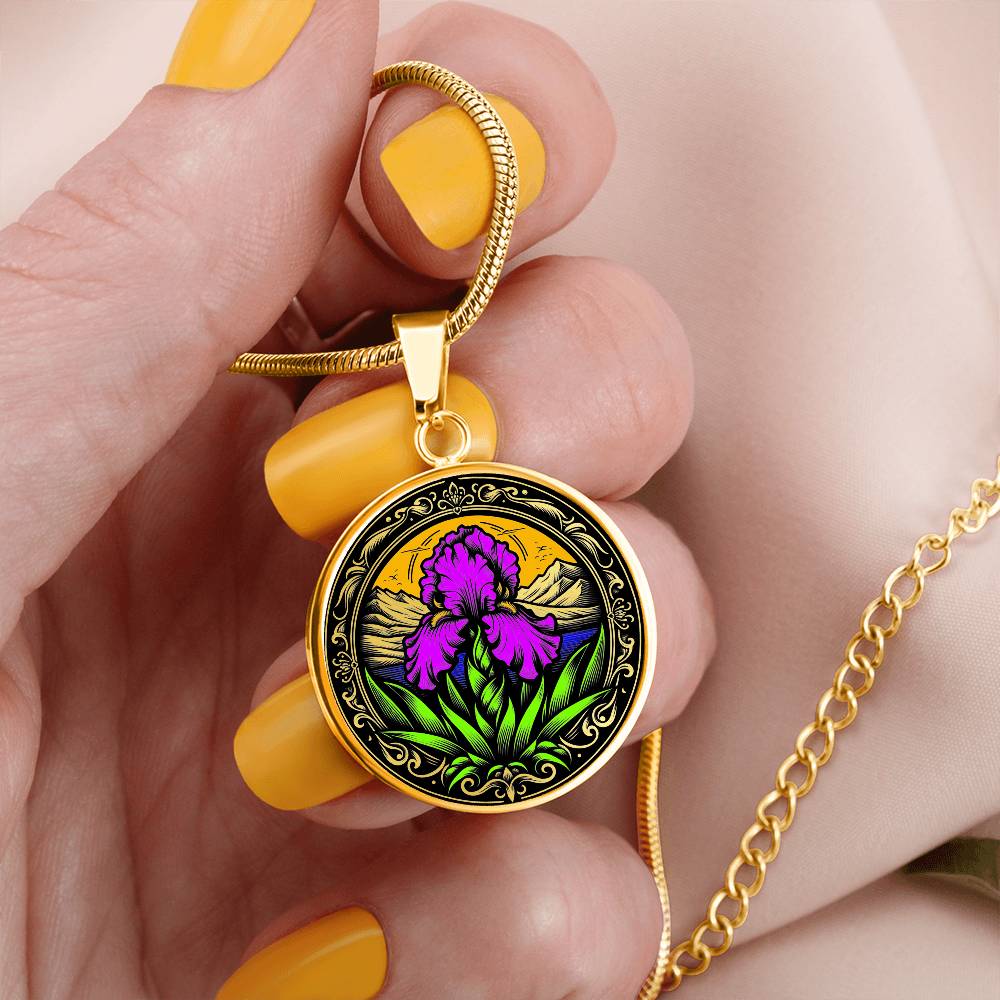 Woman holding an Elegant gold pendant necklace featuring a vivid Purple Iris set against a sunset mountains with a river, the mountains are colored by the metal shinning through. This necklace offers personalization option for a name.