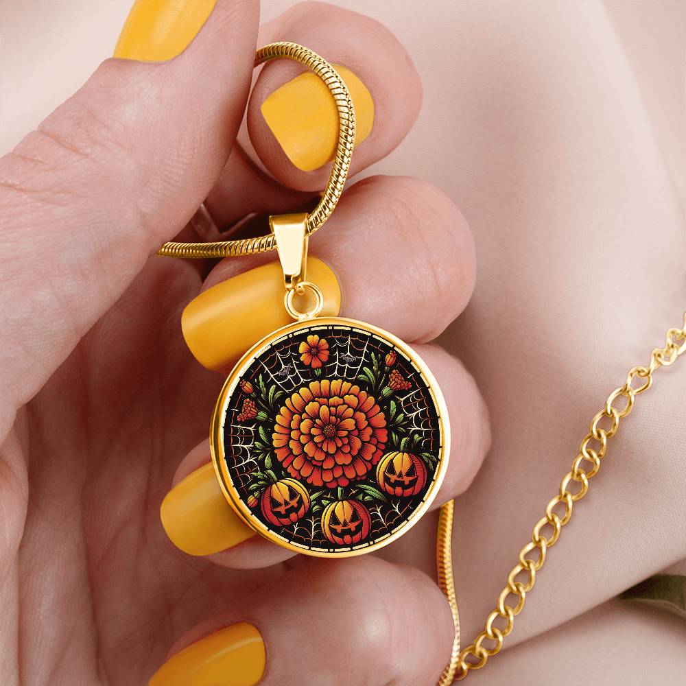Woman holding an elegant Gold Pendant Orange Marigold Flower Necklace, With green grass, white spider web, Orange Jack O Lanterns and Black bats. This necklace offers personalization option for a name.