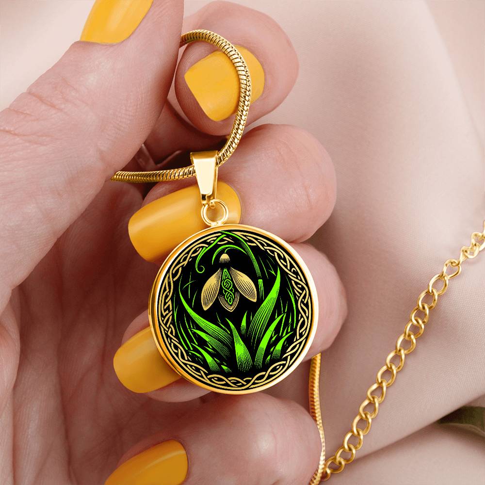 Woman holding an Elegant gold pendant featuring a vivid Snowdrop Birth Flower Necklace, January birth month flower, set against a Green & Black backdrop with a Celtic border. This jewelry offers personalization with an engraving option for a name.