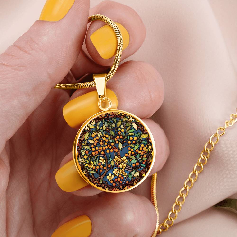Woman holding an elegant gold pendant Hawthorn Necklace. Colors yellow Flowers, Green Leaves, Brown branches, Blue Background, Orange Berries. This jewelry offers personalization with an engraving option for a name.