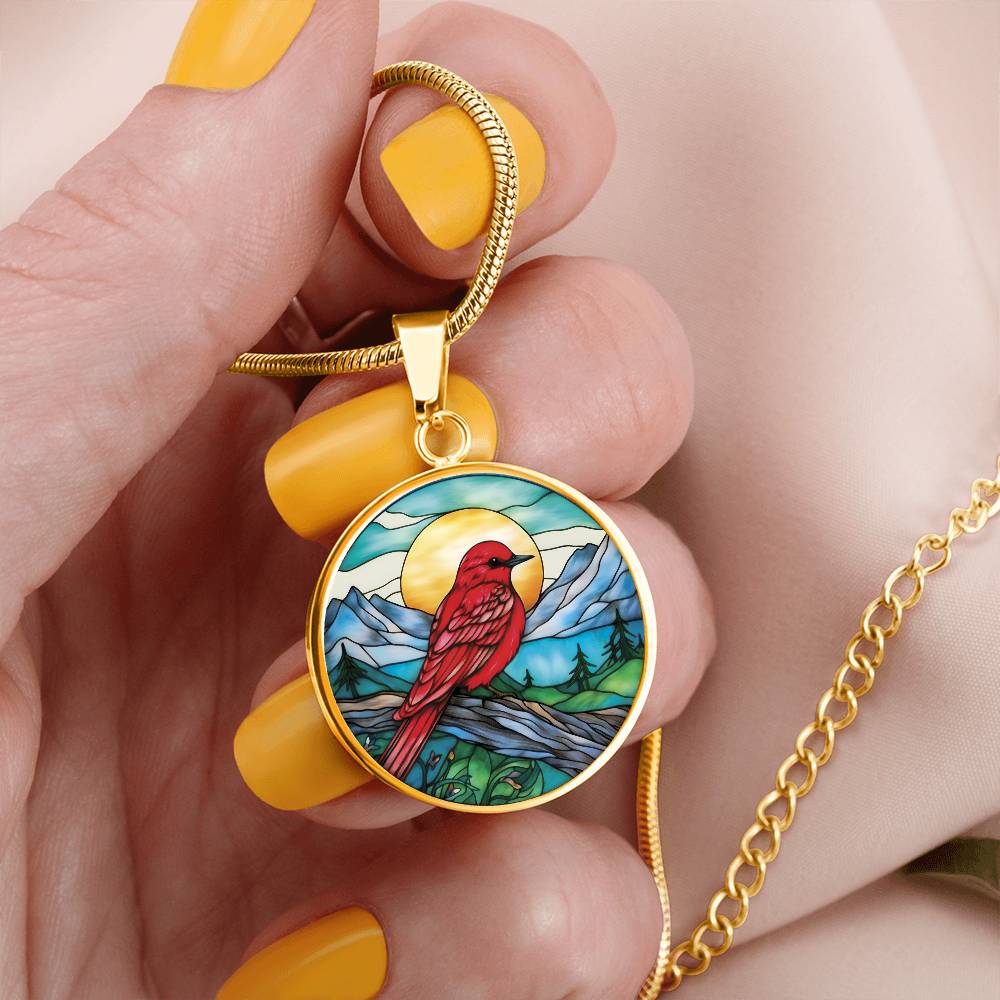 woman holding An Elegant gold pendant Red Bird Necklace. featuring a Sunny blue sky with mountains, blue lake and green forest. This jewelry offers personalization with an engraving option for a name.