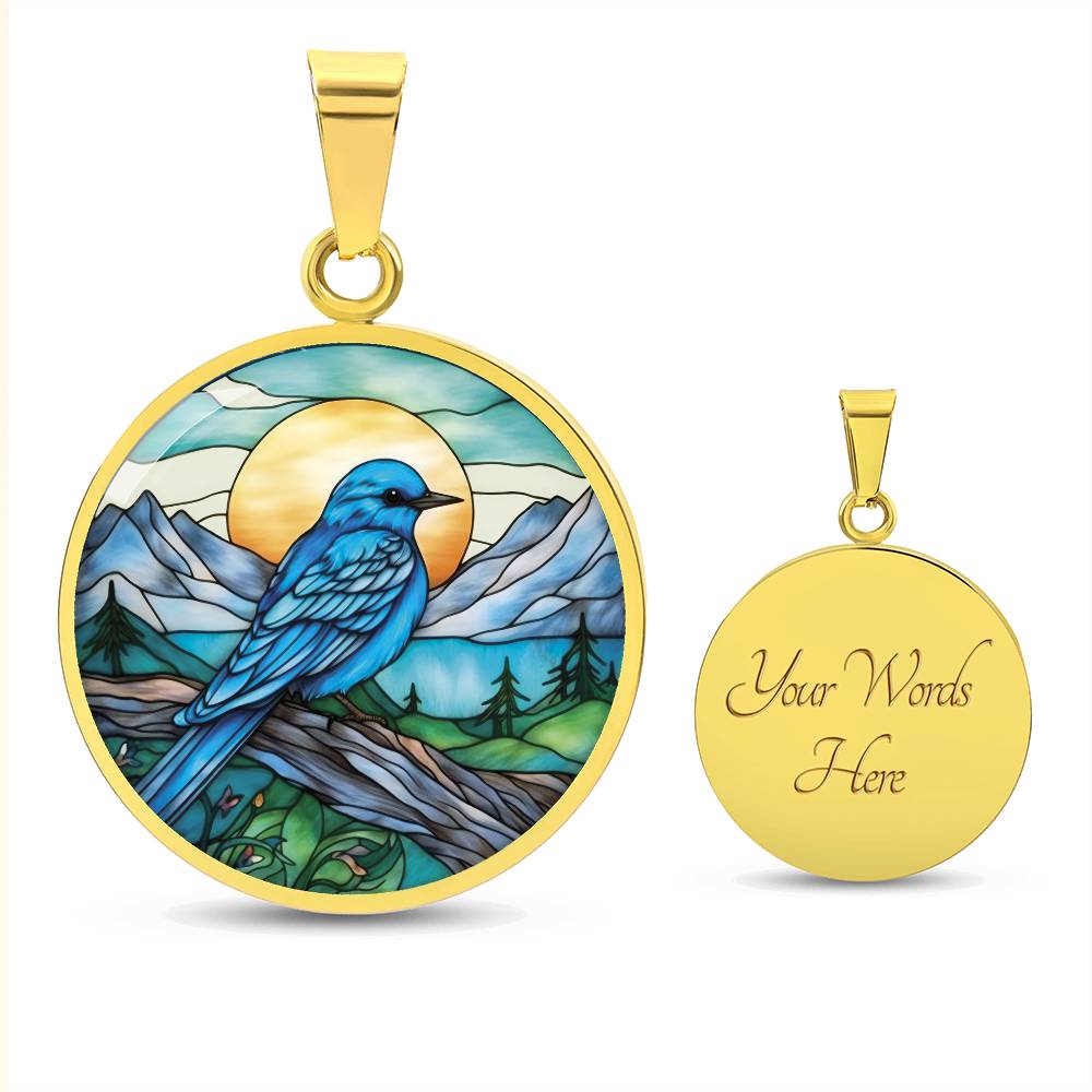 an Elegant gold pendant Blue Bird necklace. Colors blue bird and water, yellow sun, green trees and grass, brown branch, blue and white sky/ mountains. This jewelry offers personalization with an engraving option for a name.