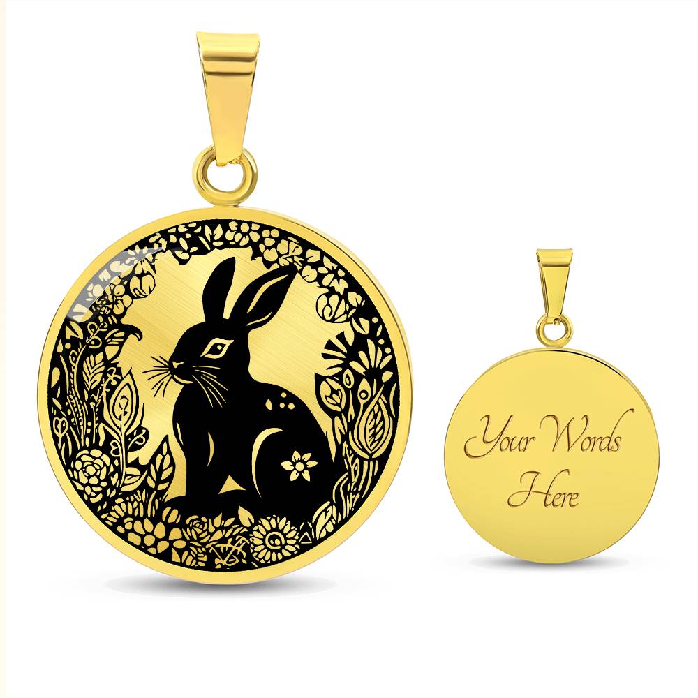 an Elegant gold pendant Easter Bunny necklace featuring a bunny with leaves and flowers all in gold with a black background. This jewelry offers personalization with an engraving option for a name.