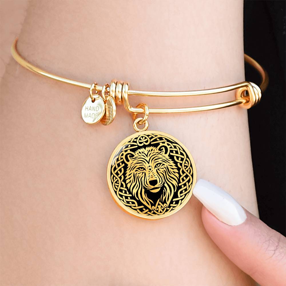 Woman wearing an Elegant Gold Personalized Bear Bracelet featuring a vivid gold bear, set against a Celtic gold and black backdrop. This jewelry offers personalization with an engraving option for a name.