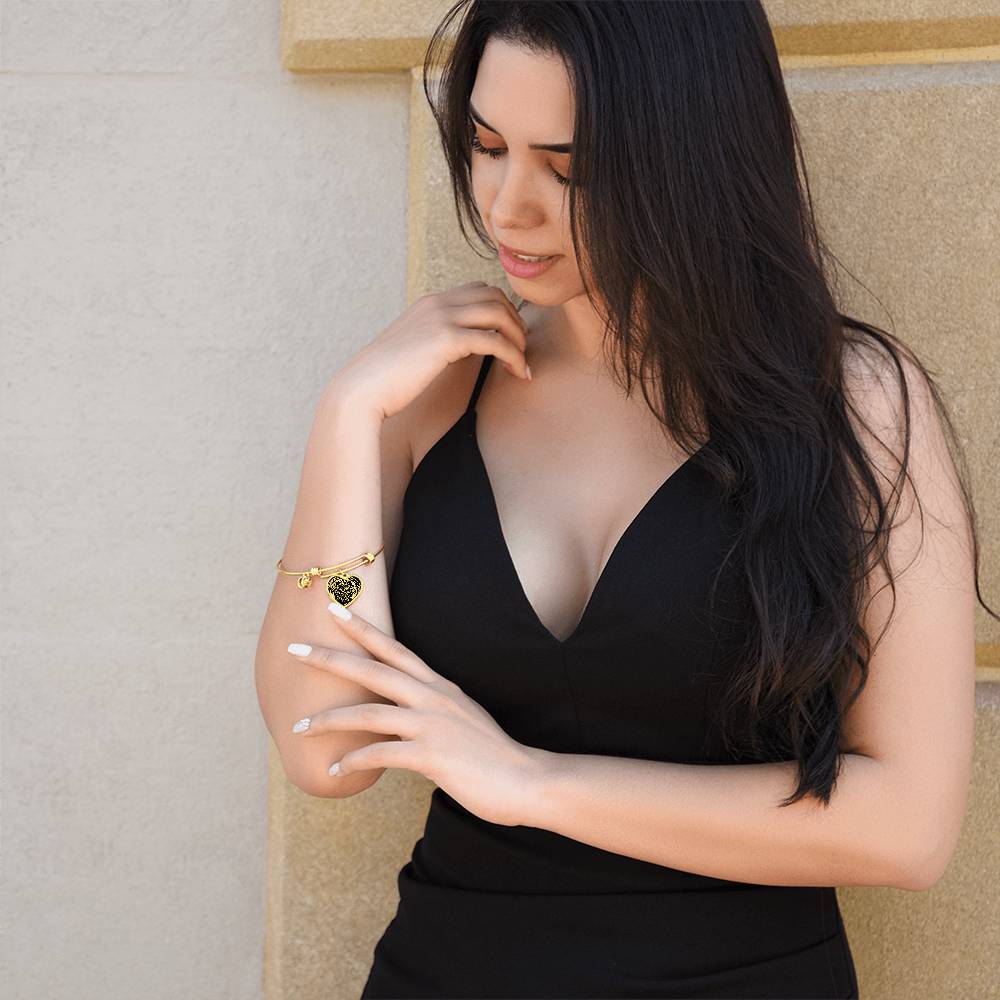 Woman wearing an elegant gold pendant Celtic Owl Bracelet. Colors are gold and black. This jewelry offers personalization with an engraving option for a name.