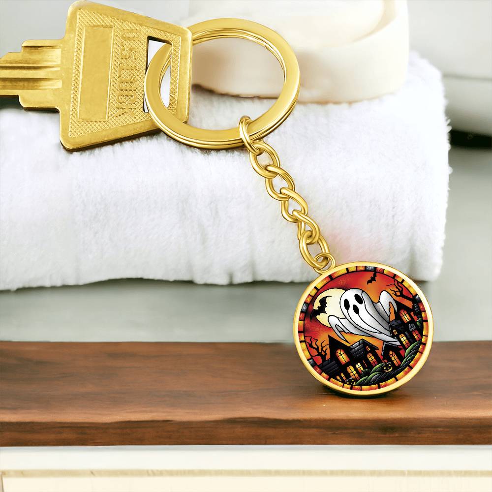 An elegant gold pendant Halloween Ghost Keychain. The colors are white, black, yellow, orange and green. This jewelry offers personalization with an engraving option for a name.