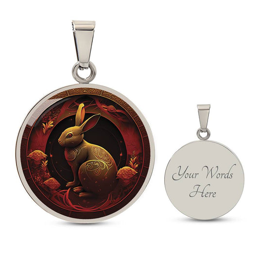 Elegant silver pendant Year of the rabbit necklace set against a subtle black and red backdrop. The Rabbit is in gold and black colors with red eyes. This jewelry offers personalization with an engraving option for a name.