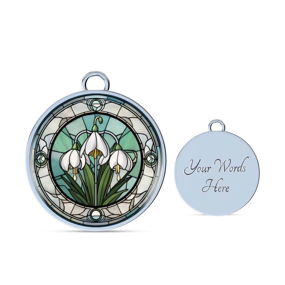 an Elegant silver pendant Snowdrop Flower Bracelet, Januarys birth month flower, set against a subtle green and grey backdrop. This jewelry offers personalization with an engraving option for a name.