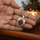 Woman holding an Elegant Silver pendant featuring a vivid red Rose, June's birth month flower, set against a subtle stained glass backdrop. This necklace offers personalization with an engraving option for a name.