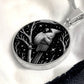 An Elegant silver pendant featuring a vivid Silver Northern Cardinal Necklace with Stars and a tree Branch all in a silver and black backdrop. This jewelry offers personalization with an engraving option for a name.