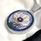 an Elegant silver pendant Anemone Necklace. The Colors are Purple Gray, Dark Green. This jewelry offers personalization with an engraving option for a name.