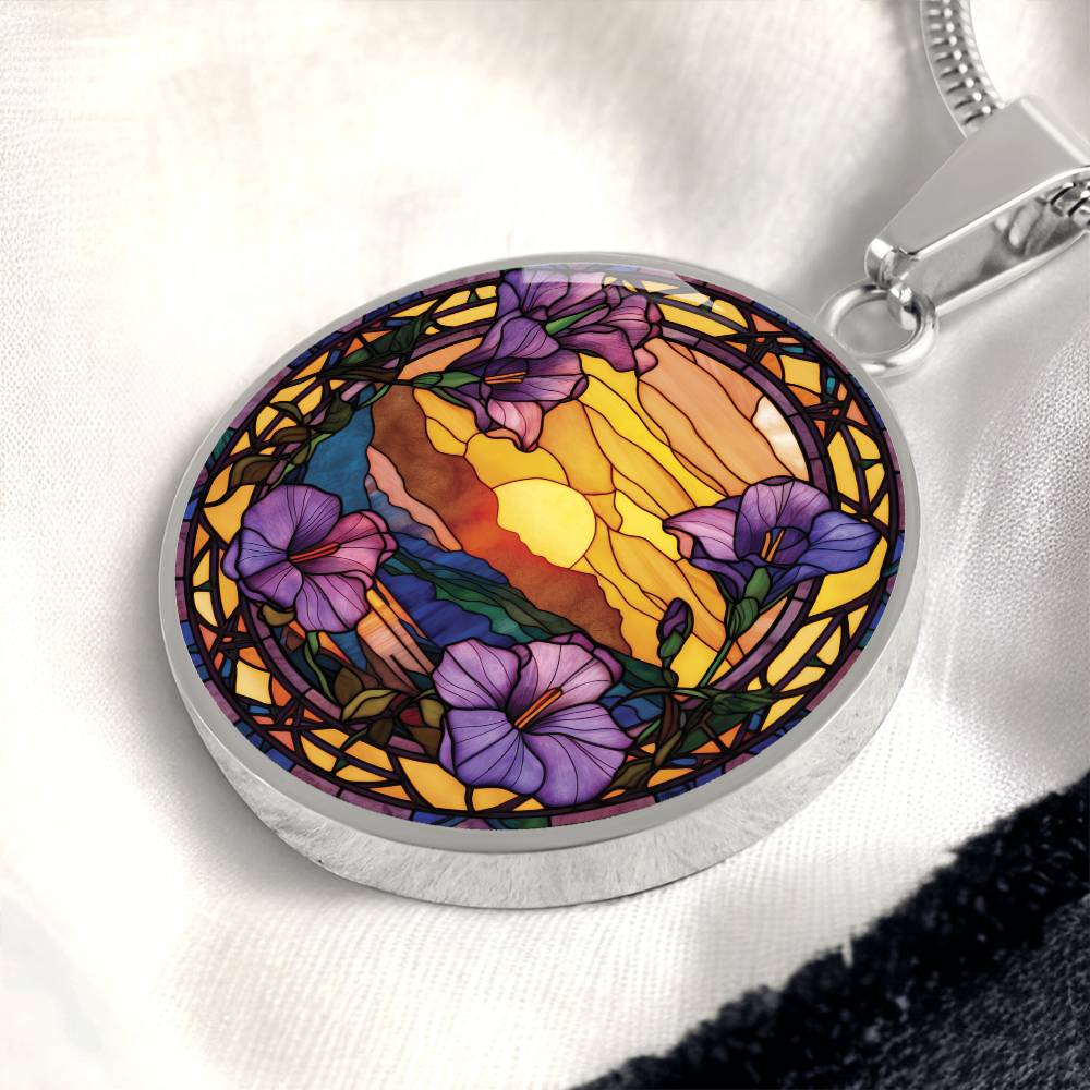 an elegant silver pendant Morning Glory Necklace. The colors are purple flowers, blue/green/purple hills, Brown mountains, Yellow sun and sky. This jewelry offers personalization with an engraving option for a name.