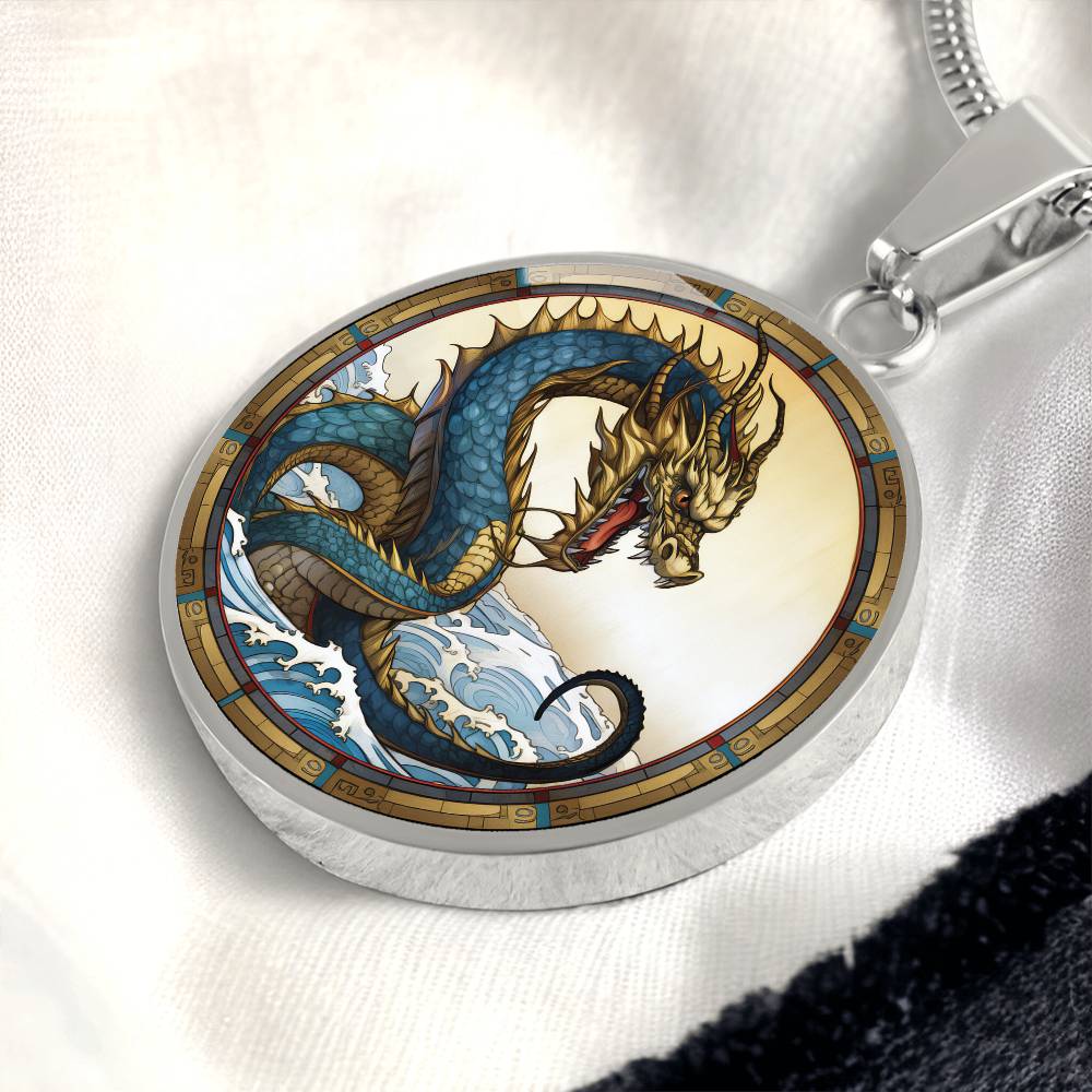 An Elegant silver pendant featuring a Water Dragon Necklace. Blue and yellow Dragon with a blue ocean, tan border and backdrop. This jewelry offers personalization with an engraving option for a name.