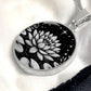 An Elegant silver pendant Water Lily Necklace featuring Stars, Lily Pads and a Water lily, all in black and silver. This jewelry offers personalization with an engraving option for a name.