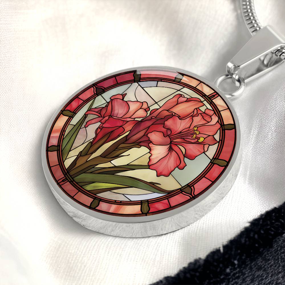 an elegant silver pendant Gladiolus Necklace. The colors are tan/green/blue/purple background, red and pink flowers, green grass, red border. This jewelry offers personalization with an engraving option for a name.