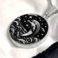 Elegant silver pendant featuring a vivid Silver Dolphin Necklace with a Stars and Ocean Waves set against a silver and black backdrop. This jewelry offers personalization with an engraving option for a name.