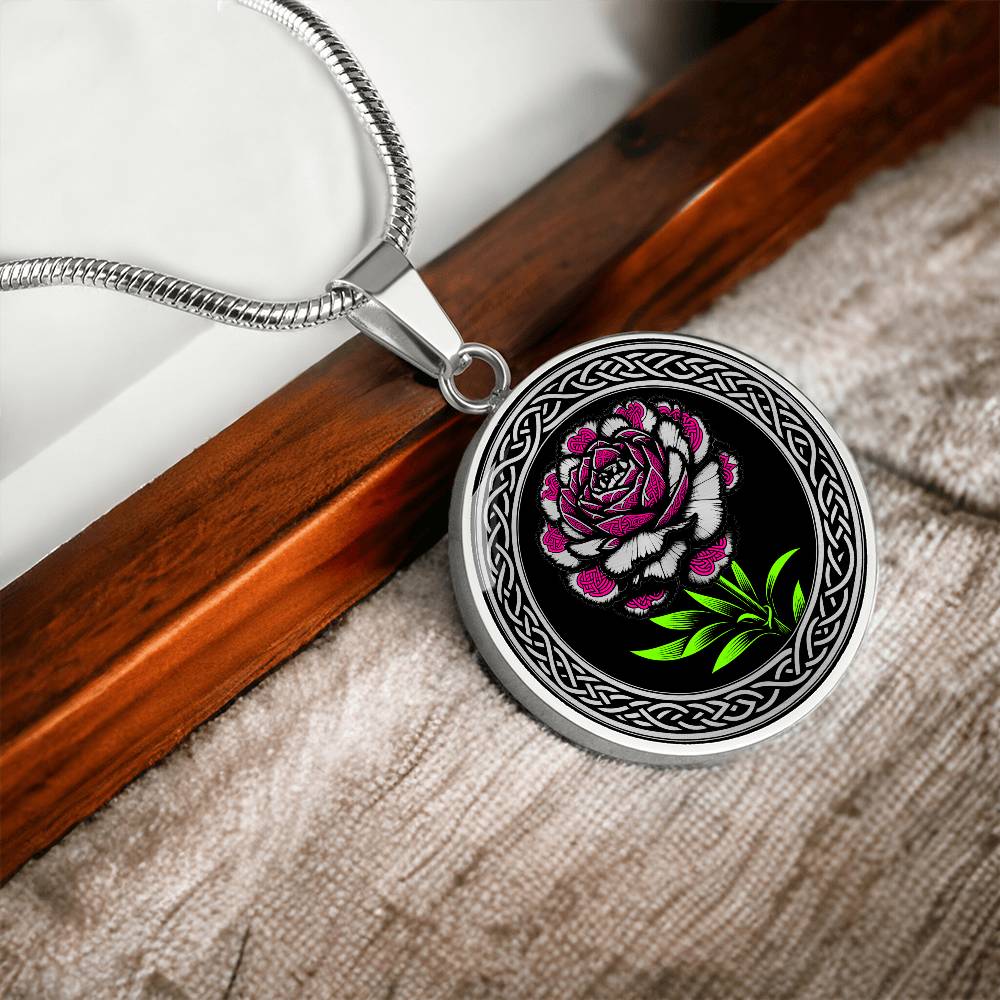 an Elegant January silver pendant Celtic Carnation Birth Flower necklace featuring a vivid pink, green and silver flower, set against a black backdrop. This jewelry offers personalization with an engraving option for a name.