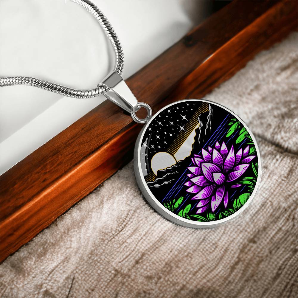 An Elegant silver pendant Water Lily Necklace featuring Mountains, Stars, Yellow outline Sun, Green grass Lily Pads, Blue Water, Pink lily, black and silver Background. This jewelry offers personalization with an engraving option for a name.