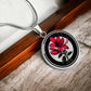 Elegant silver pendant featuring a vivid red honeysuckle, Junes birth month flower, set against a subtle tan backdrop. This necklace offers personalization with an engraving option for a name.
