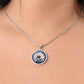 Woman wearing an Elegant silver pendant Anemone Necklace. The Colors are Purple Gray, Dark Green. This jewelry offers personalization with an engraving option for a name.