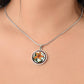 Woman wearing an Elegant Silver pendant necklaces features an Orange Tiger Lily, Green Grass, white background with a red and brown frame. This necklace offers personalization with an engraving option for a name.