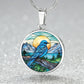 an Elegant silver pendant Blue Bird necklace. Colors blue bird and water, yellow sun, green trees and grass, brown branch, blue and white sky/ mountains. This jewelry offers personalization with an engraving option for a name.