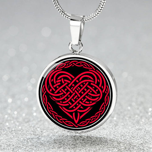 Elegant silver pendant featuring a vivid red Heart Celtic Necklace set against a Black & silver backdrop. This jewelry offers personalization with an engraving option for a name.