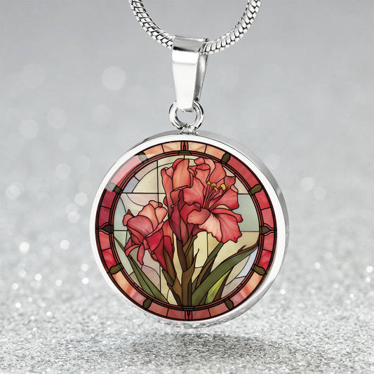 an elegant silver pendant Gladiolus Necklace. The colors are tan/green/blue/purple background, red and pink flowers, green grass, red border. This jewelry offers personalization with an engraving option for a name.