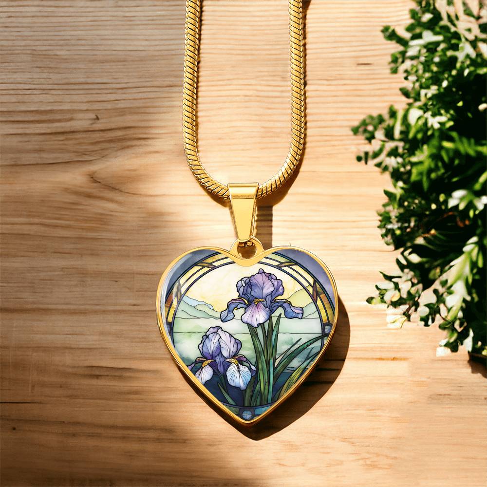 Gold Heart Pendant Purple Iris flower necklace, With green grass, a Yellow sunset and Green mountains. This necklace offers personalization option for a name.