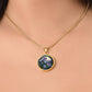 Woman wearing a Gold Pendant Purple Morning Glory necklace, With green grass, a Yellow sky and purple mountains, Blue Lake, Muti Colored Border. This necklace offers personalization option for a name.