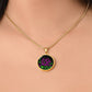 Woman wearing an Elegant gold pendant featuring a vivid Purple African Violet Birth Flower Necklace with green grass, gold stars set against a Black backdrop. This jewelry offers personalization with an engraving option for a name.