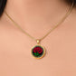 Woman wearing an elegant Celtic gold pendant January Birth Flower Carnation necklace. A vivid red carnation, green stem & leaves, set against a gold & black backdrop. This jewelry offers personalization with an engraving option for a name.