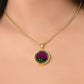 Woman wearing an Elegant January Gold pendant Celtic Birth Flower Carnation Necklace. Featuring a vivid pink flower with green leaves, set against a gold & black backdrop. This jewelry offers personalization with an engraving option for a name.