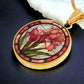 an elegant gold pendant Gladiolus Necklace. The colors are tan/green/blue/purple background, red and pink flowers, green grass, red border. This jewelry offers personalization with an engraving option for a name.